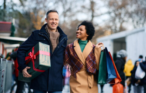 Happy multiracial couple enjoying in Christmas shopping.