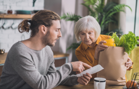 grey haired mom and her son talking in the kitchen