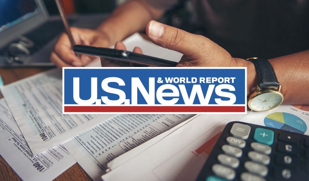 Logo of U.S. New & World Report overlaid on image of person filling out IRS tax forms
