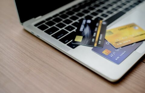 Multiple credit cards scattered on a laptop keyboard