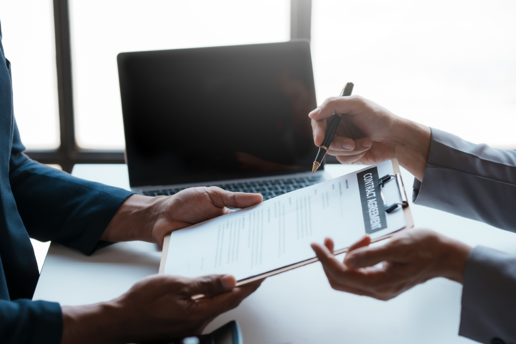 Close-up of two professionals discussing and signing a contract agreement