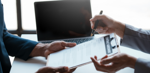 Close-up of two professionals discussing and signing a contract agreement