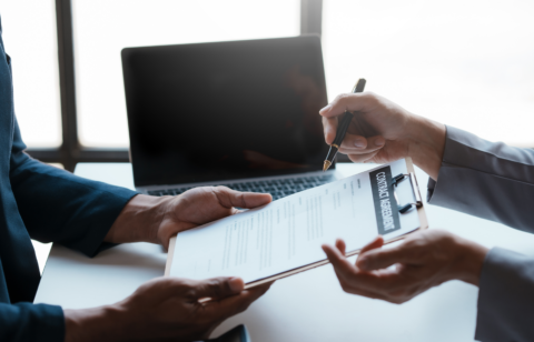 Close-up of two professionals discussing and signing a contract agreement