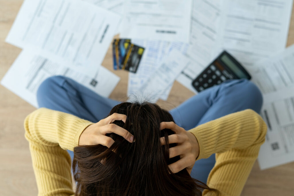 frustrated person looking at bills and credit cards