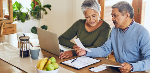 Older couple looks at bills and budget worksheet
