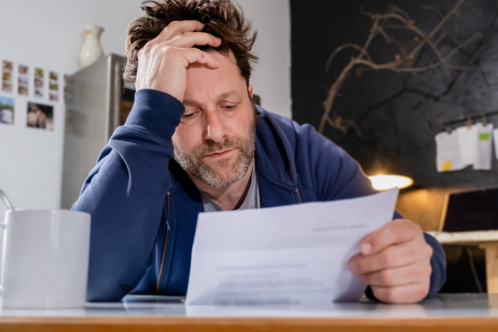 tired man looking at a bill