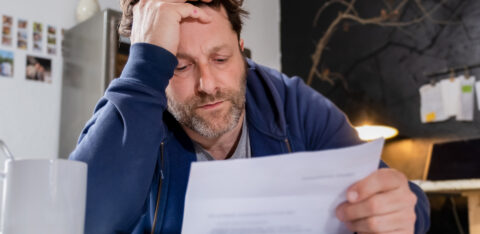 tired man looking at a bill