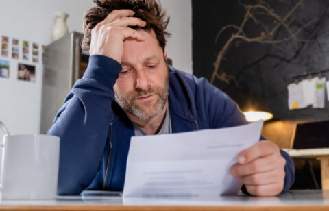 tired man looking at a bill