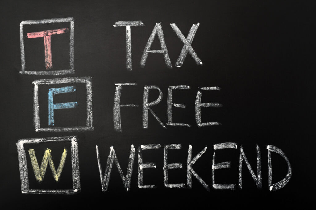 A chalkboard sign displaying "Tax-Free Weekend" in bold, hand-drawn lettering