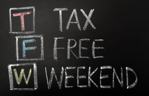 A chalkboard sign displaying "Tax-Free Weekend" in bold, hand-drawn lettering