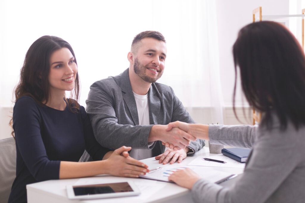 Happy clients shaking hands with a professional consultant, discussing financial or credit counseling services.