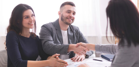 Happy clients shaking hands with a professional consultant, discussing financial or credit counseling services.