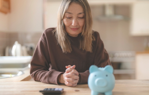 woman with blue piggy bank in front of her