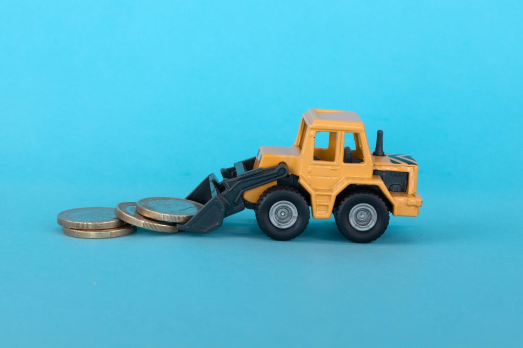 Miniature construction vehicle moving coins