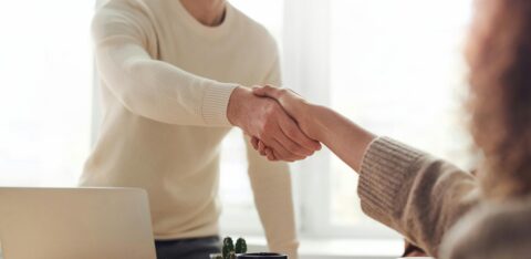 Two people shaking hands in an office setting