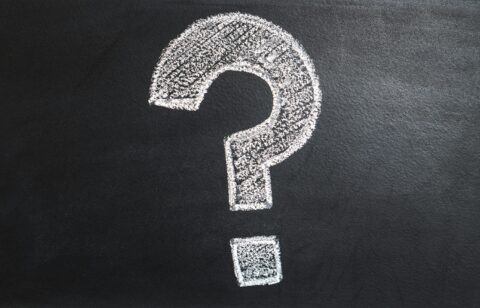White chalk-drawn question mark on a blackboard background.