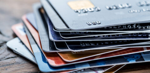 Stack of various credit cards on a wooden surface