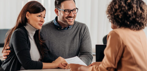 Smiling couple meeting with a professional advisor at a desk