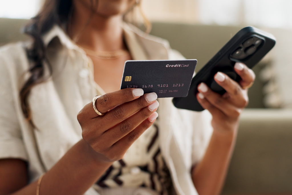 Woman holding a credit card in one hand and a smartphone in the other
