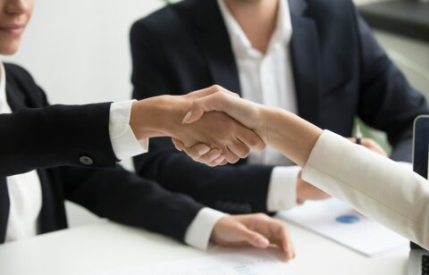 Close-up of a professional handshake between two people in business attire