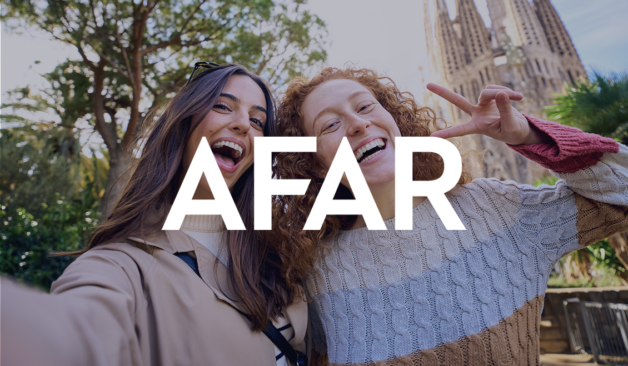 Two smiling women take a selfie in front of La Sagrada Família in Barcelona, with the AFAR logo overlaid on the image.