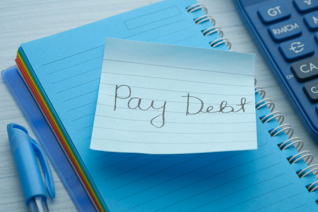 Loan agreement document on a dark desk with a pen, calculator, and stack of cash nearby.