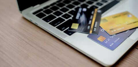 Laptop with multiple credit cards on the keyboard, representing online transactions or financial management.