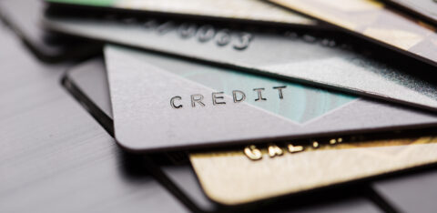 Several overlapping credit cards on a surface, shown in a blurred, close-up view