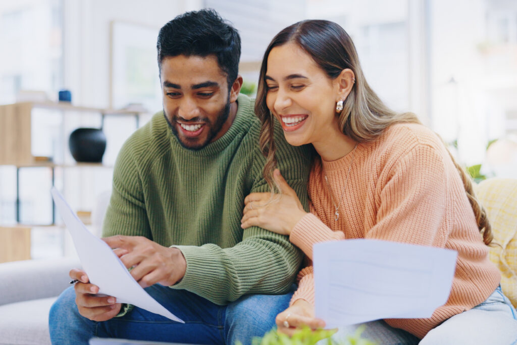 Happy man and woman looking at budgeting sheets