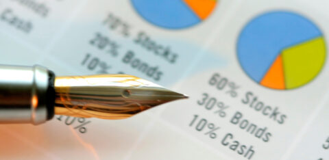 Close-up of a fountain pen resting on a financial chart showing stock, bond, and cash allocations.