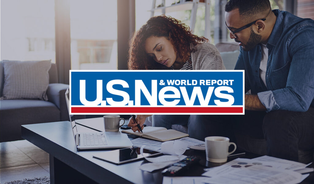 Couple reviewing finances and personal loan documents at home, with U.S. News & World Report logo overlay.