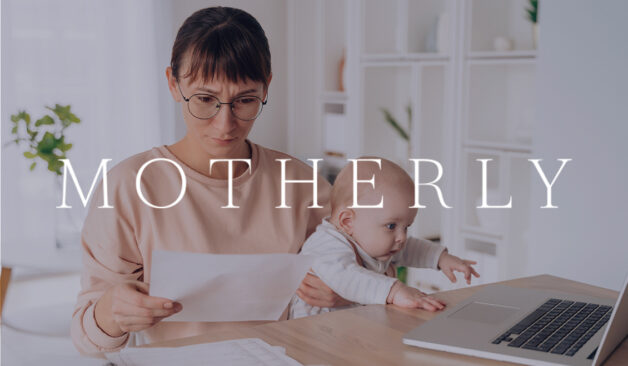A mother holding her baby while reviewing papers at a desk with a laptop, with the Motherly logo overlayed on the image.