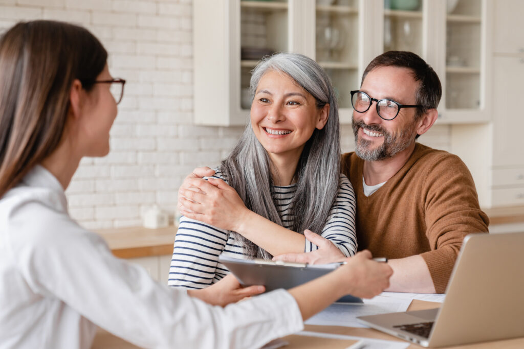 Smiling couple meeting with a financial professional at home.