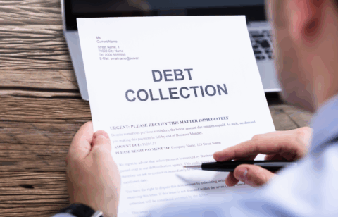 Person holding a debt collection notice with the words βDebt Collectionβ printed in large letters at the top.