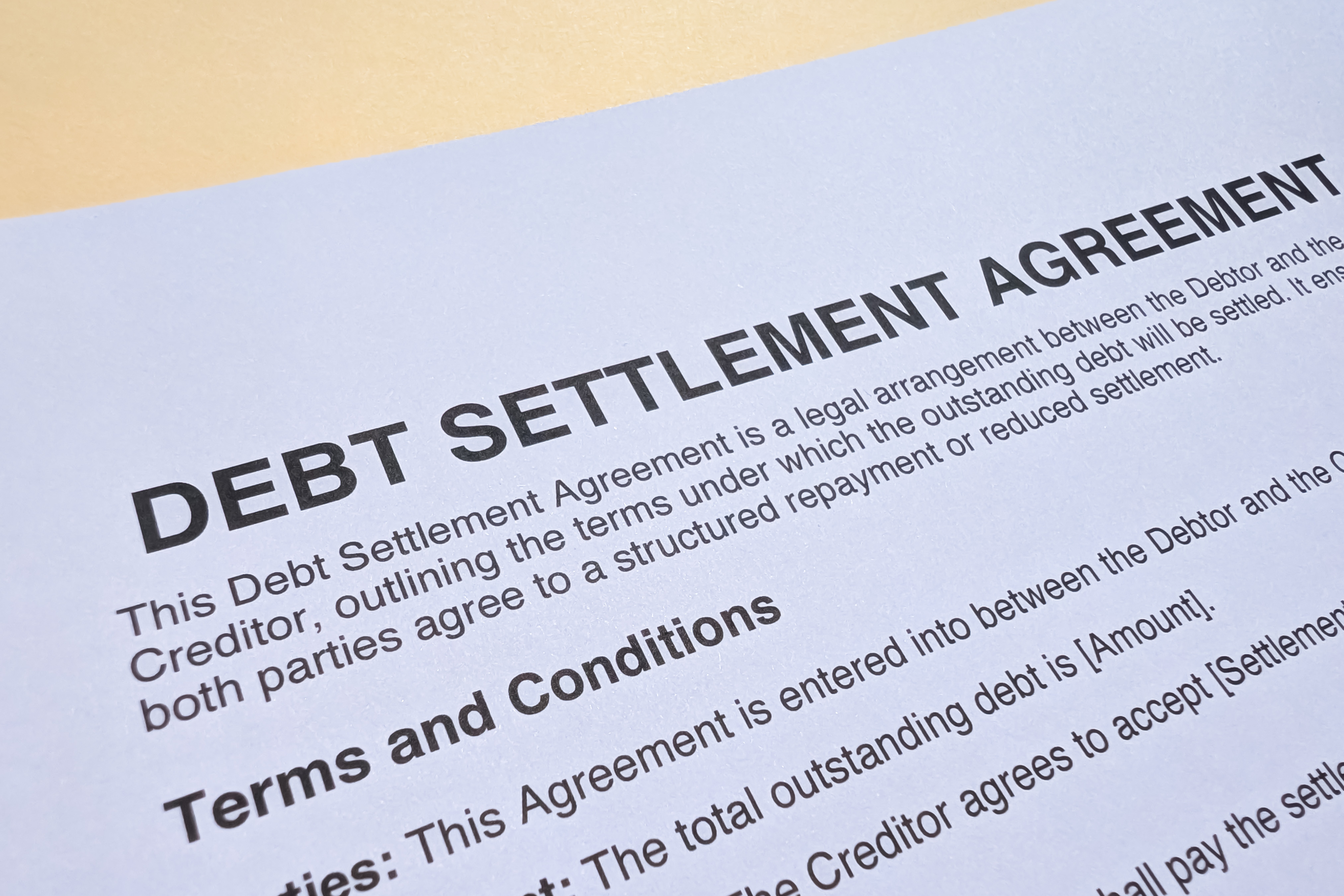 Close-up of a document titled “Debt Settlement Agreement” showing printed terms and conditions.