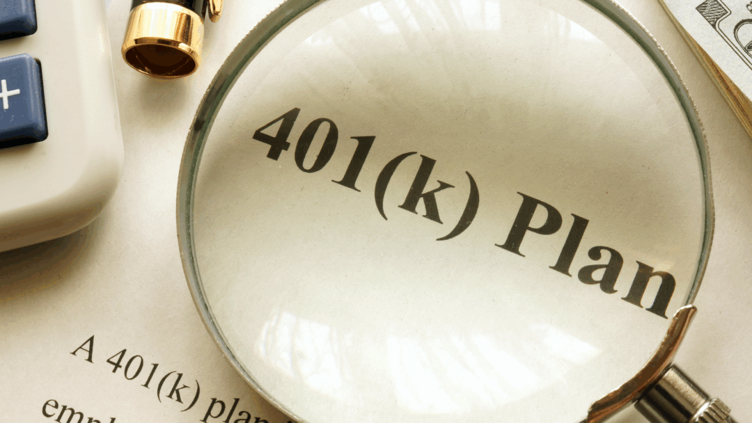 Magnifying glass highlighting the words “401(k) plan” on a printed document, with a calculator, pen, and cash nearby.
