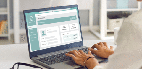 Person using a laptop to access an online banking account dashboard.