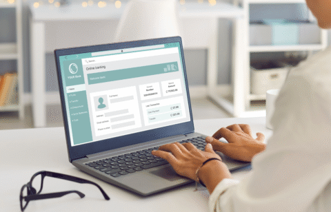 Person using a laptop to access an online banking account dashboard.