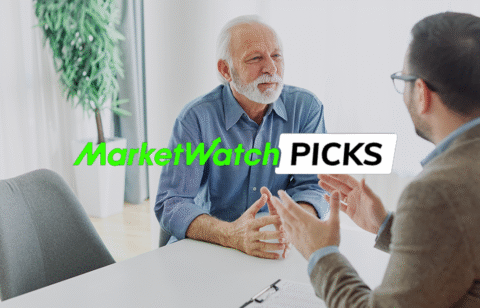 An older man talks with a financial professional across a desk in an office, with the text “MarketWatch Picks” displayed over the image.