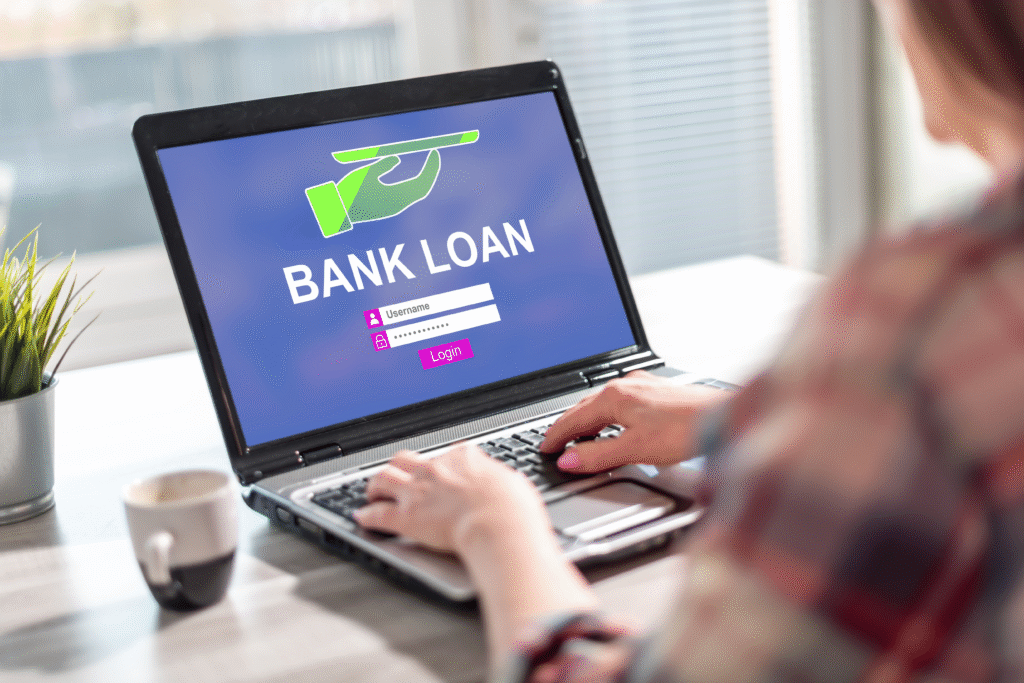Person using a laptop displaying a bank loan login screen.