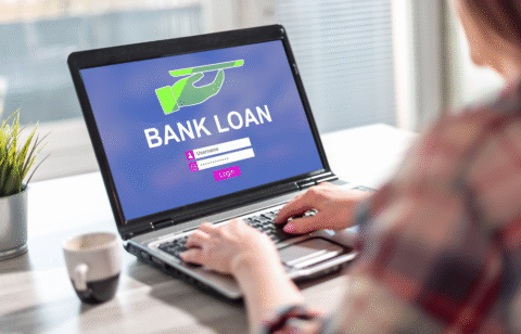Person using a laptop displaying a bank loan login screen.