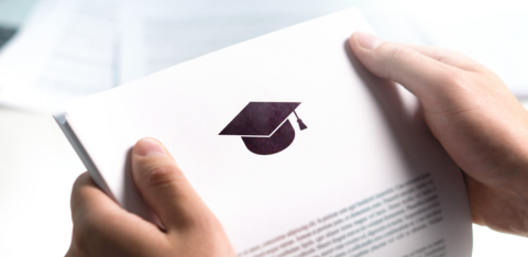 Hands holding a document with a graduation cap icon, representing student loan or education-related paperwork